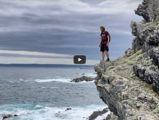 Hiker on rocky coast in Garden Route